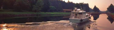 a modern motorboat on the Erie Canal at sunrise.